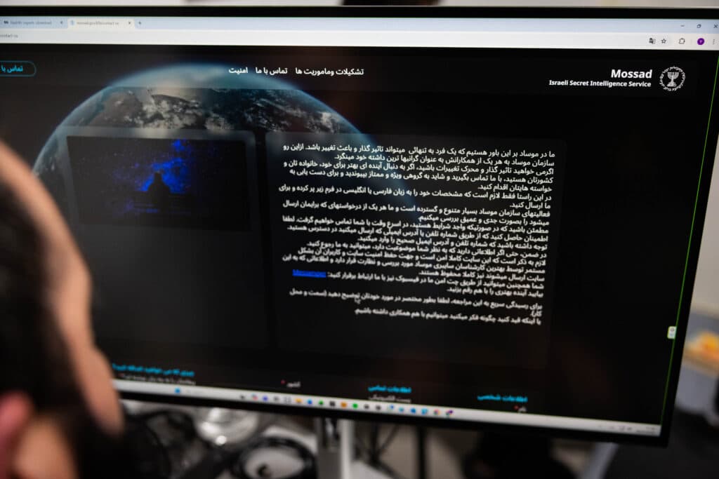 A man views a message published on the Mossad website on a computer screen.