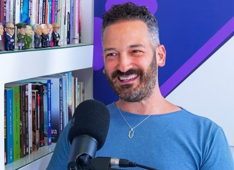 Israeli businessman Eran Efrat speaks into a microphone during a podcast interview.