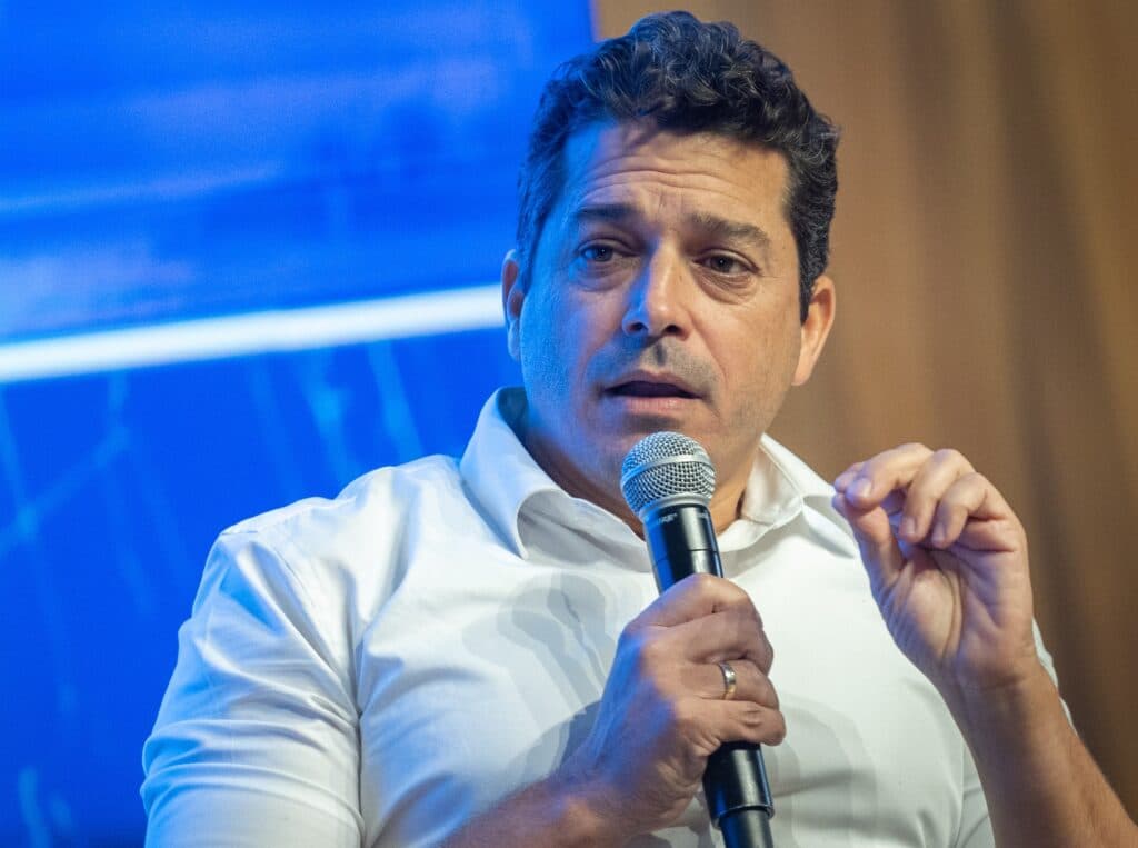 Minister Amichai Chikli speaking into a microphone at a conference in the Knesset