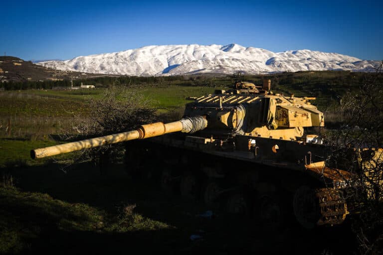 israeli tank in golan heights with snowcapped mount hermon in background