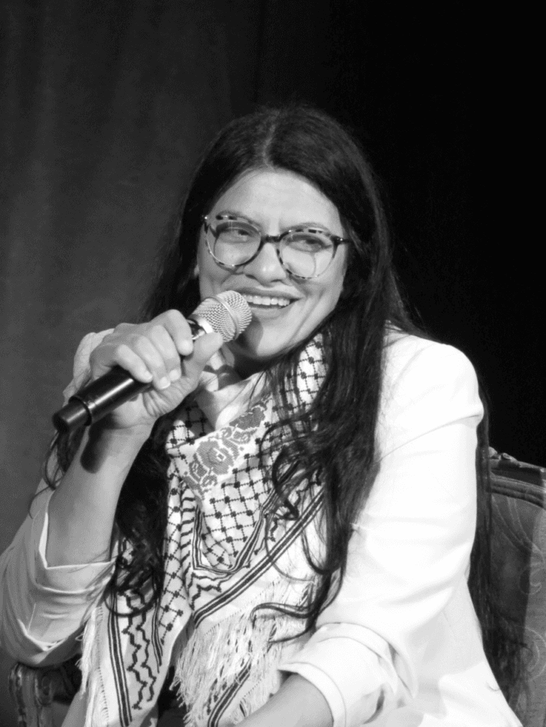 Congresswoman Rashida Tlaib speaks into a handheld microphone at an event.