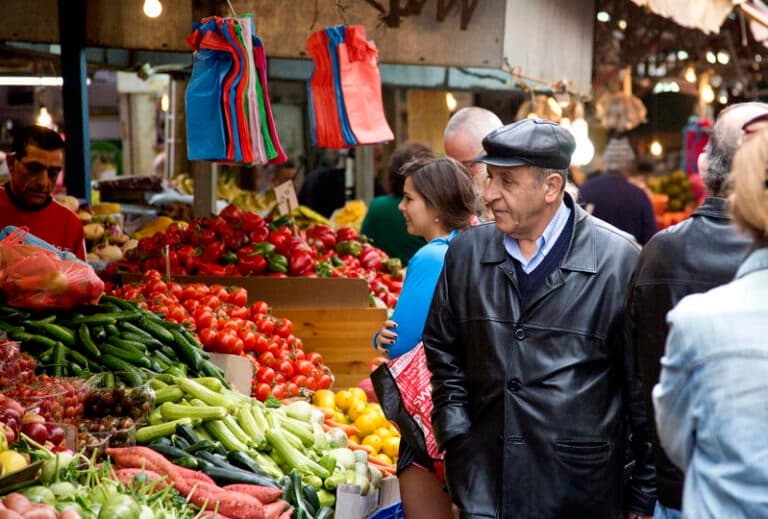 old man shopping for vegetables in open air market