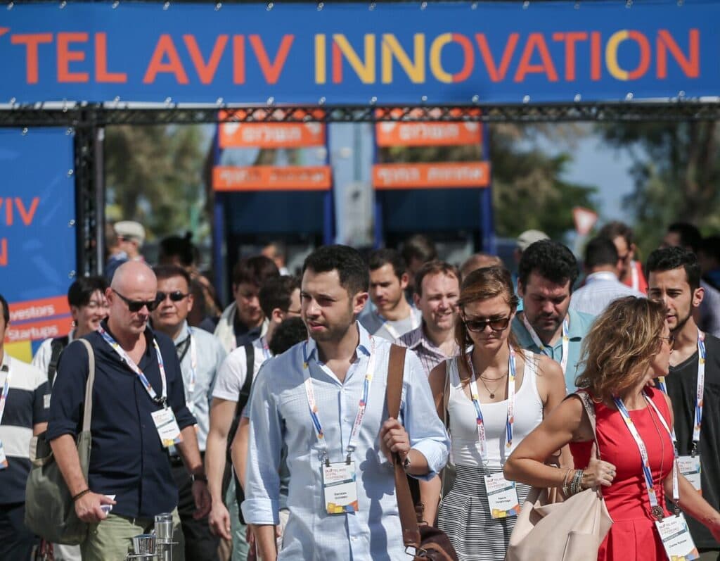 Participants walking under a DLD Tel Aviv Innovation Festival sign.
