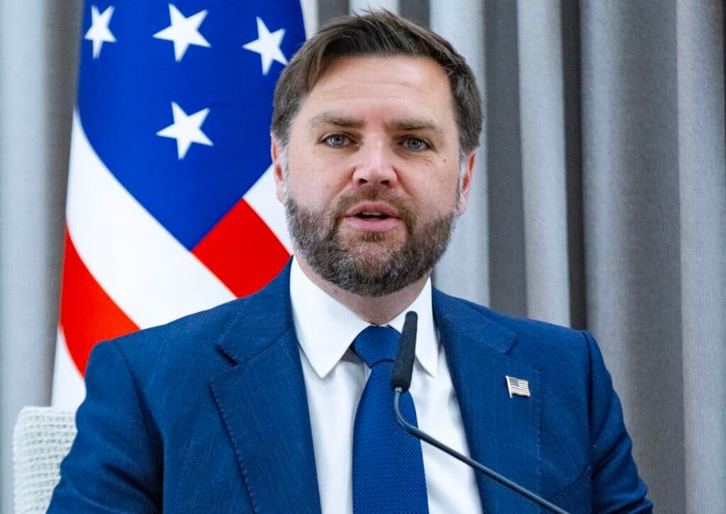 U.S. Vice President JD Vance speaking beside an American flag during a meeting in Jerusalem