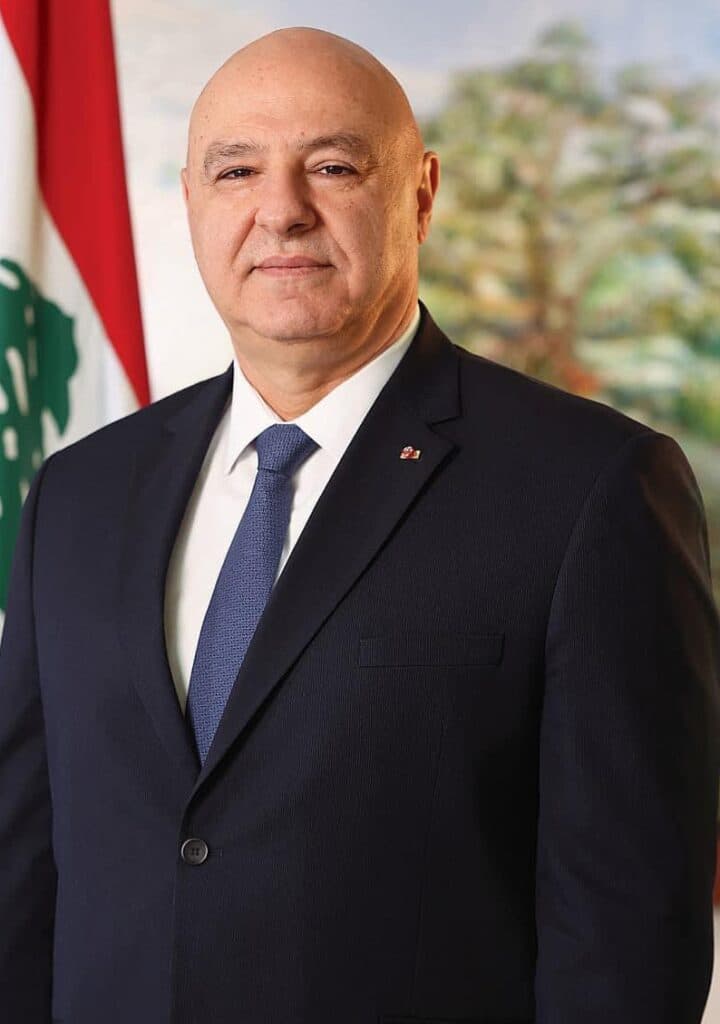 Lebanese President Joseph Aoun standing beside the Lebanese flag