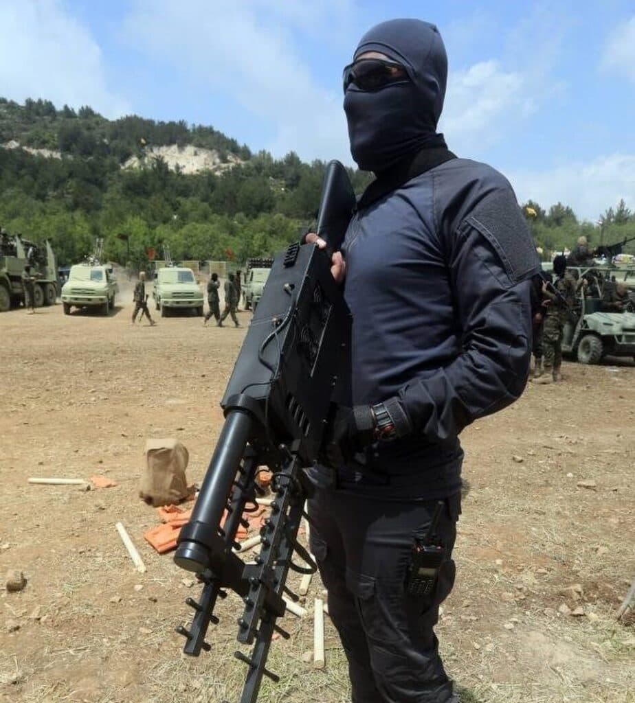 Masked Hezbollah fighter holding a weapon during a military drill in southern Lebanon.