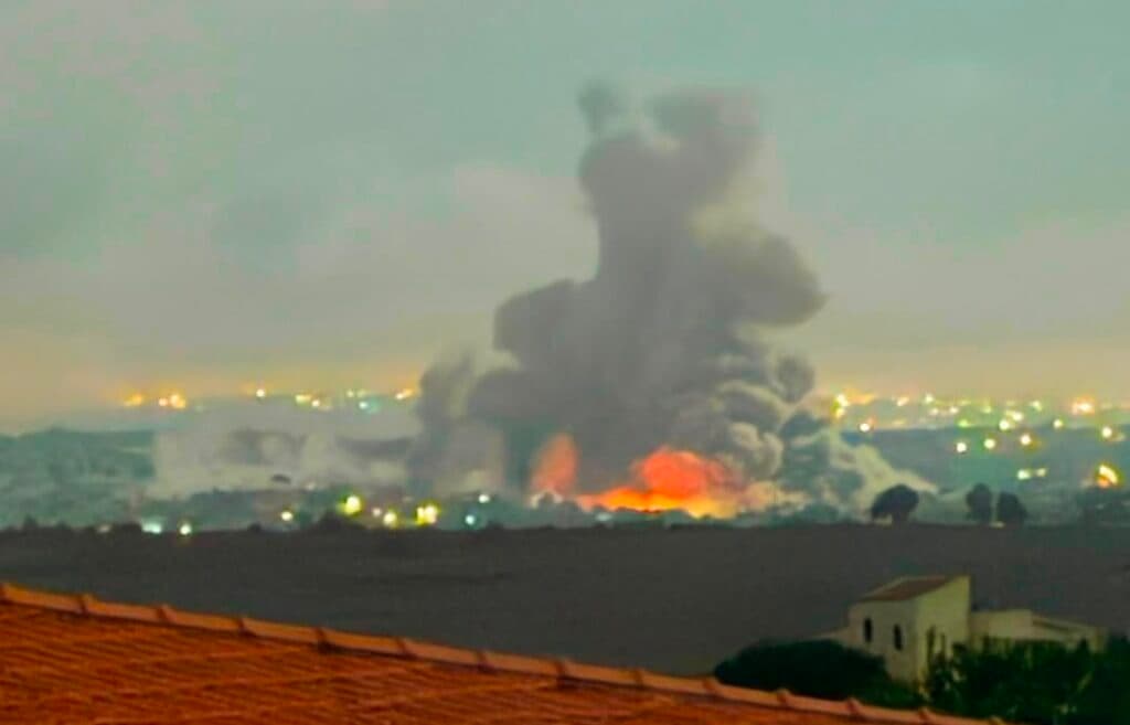 Smoke and fire rise from a large explosion in southern Lebanon at night.