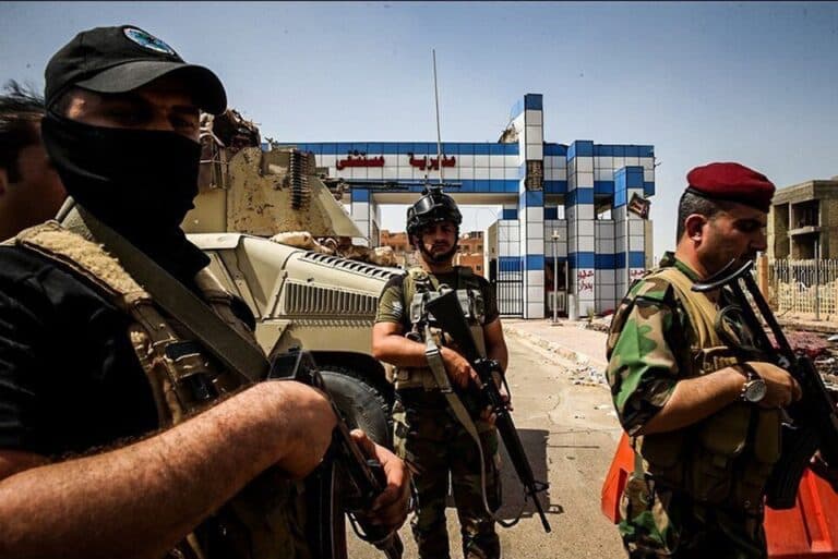 Iraqi soldiers stand armed outside a building in Fallujah.