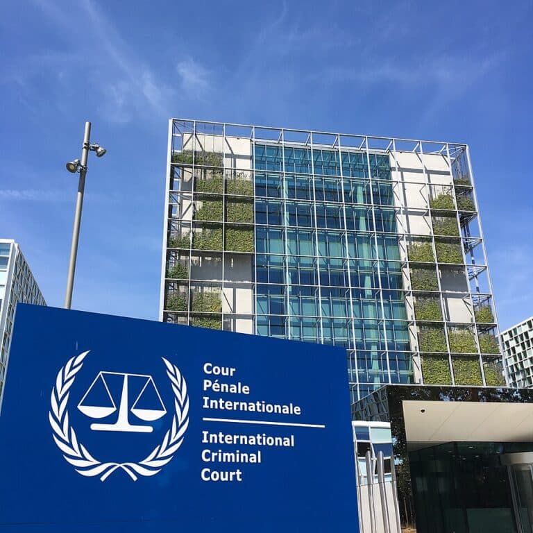 The International Criminal Court building in The Hague under a blue sky.