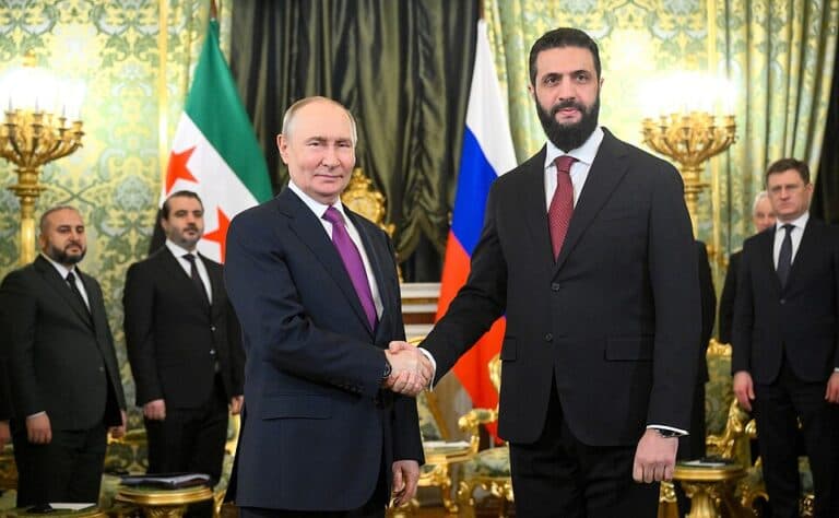 Russian President Vladimir Putin shaking hands with Syrian President Ahmed al-Sharaa in the Kremlin.